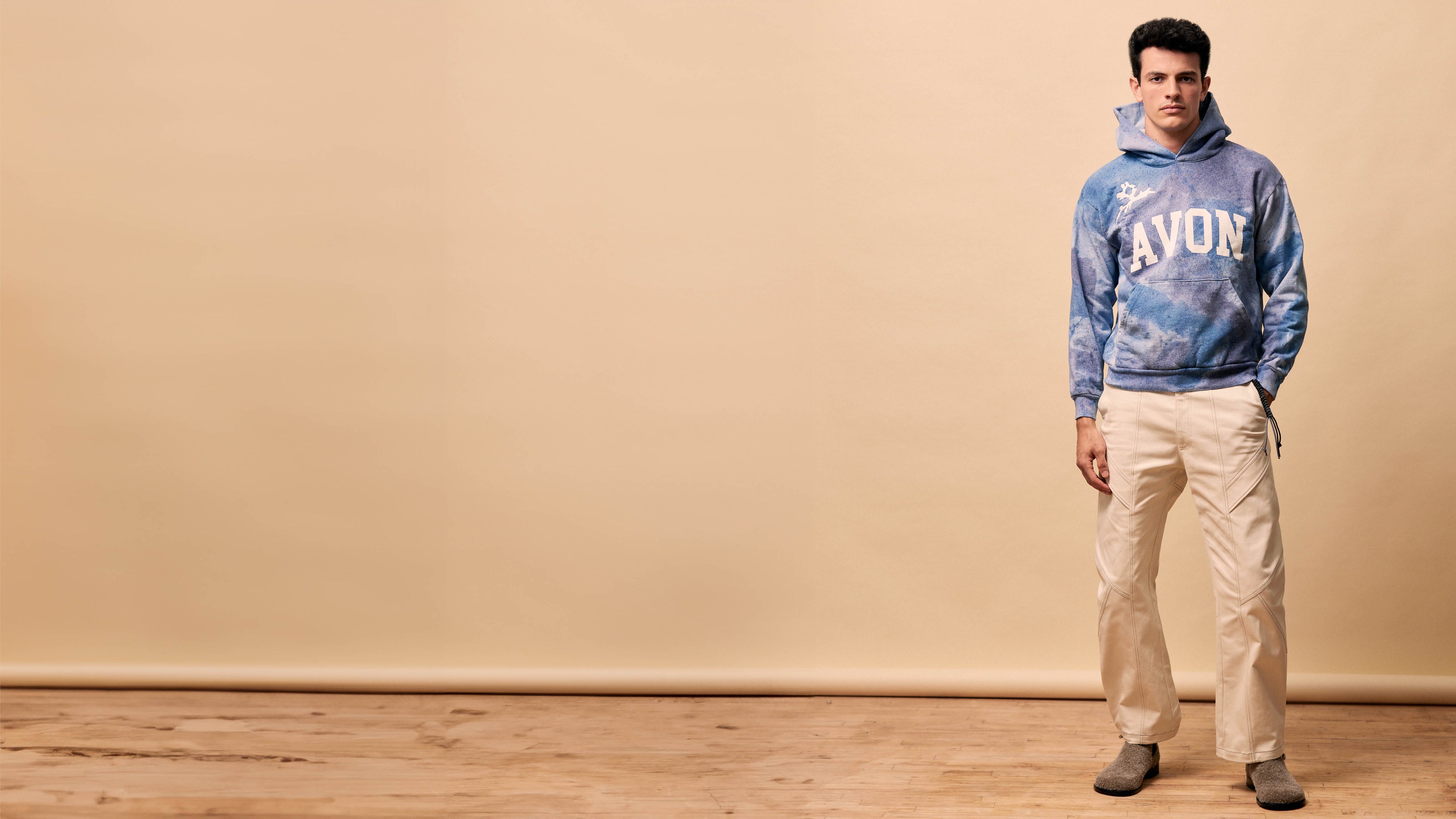 model marwan el anbari wearing a handpainted hoodie and oat colored trousers from Delivery 5 from Avon Anglers designed by Patrik Rzepski, photographed by Kevin Tachman