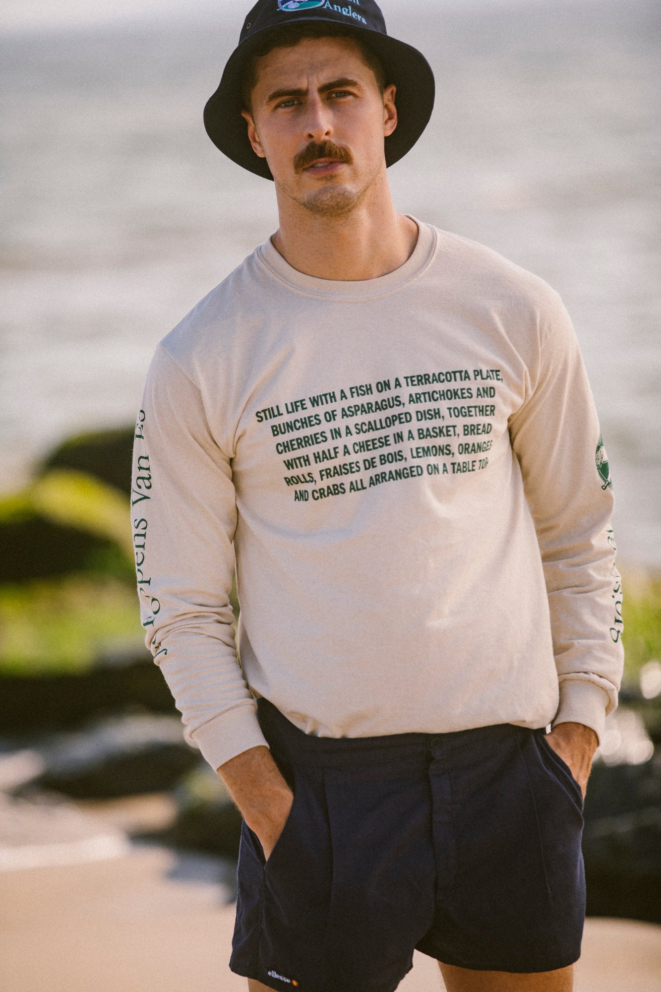 Model Nico Brown wearing Avon Anglers, Navy bucket hat and Avon Anglers x Foppens long sleeve t-shirt at the beach