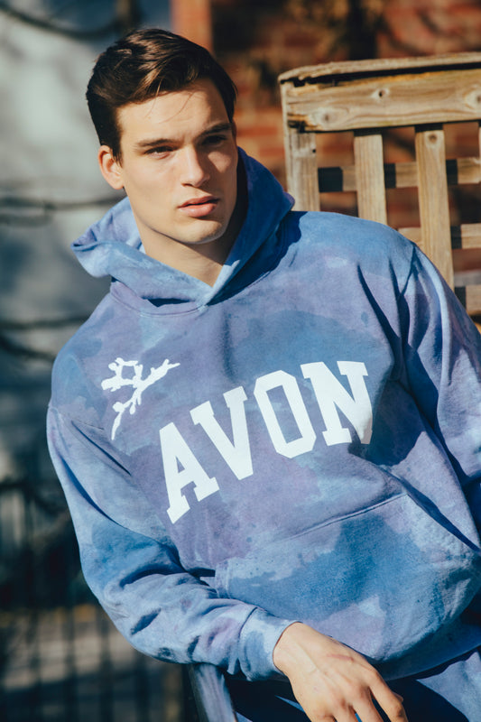 Model Mason McKenrick wears Avon Anglers hand painted camo hoodie with white embroidery and print "AVON"