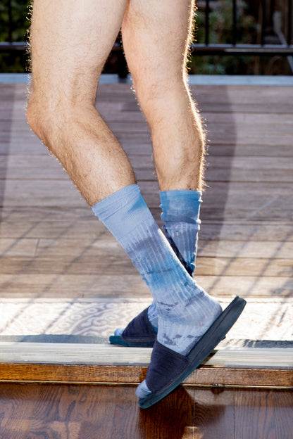 Model Mason McKenrick standing in a doorway wearing Avon Anglers hand painted blue camo socks